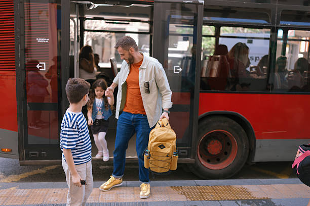 istock Dad and kids disembarking from bus 2247115701