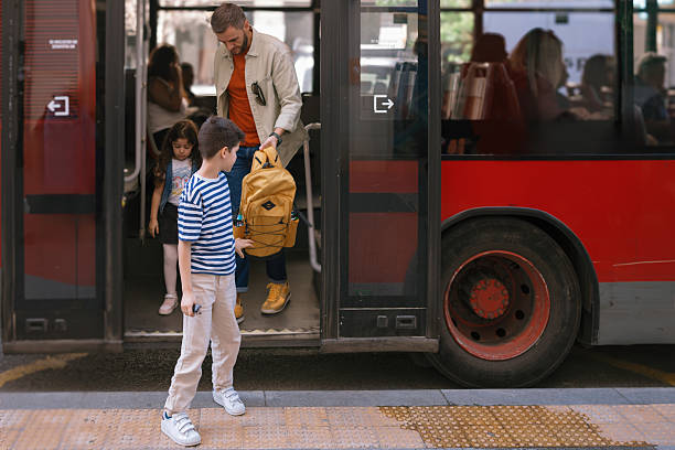 istock Dad and kids disembarking from bus 2247115711
