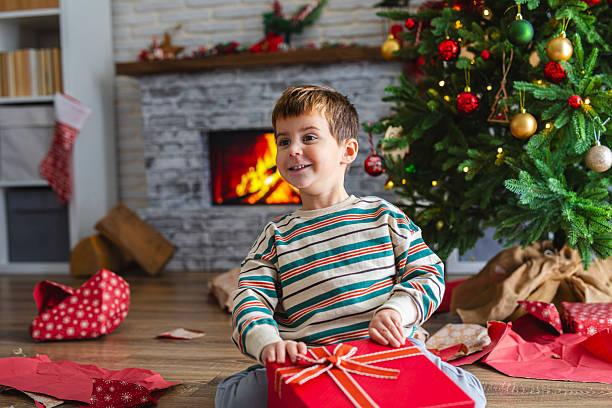 istock Little Boy Opening a Christmas Gift 2247117221