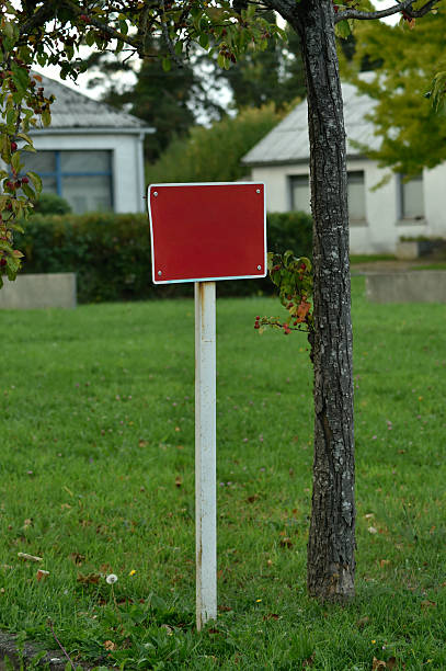 istock Blank Red Sign on Pole in Grassy Yard 2247118897