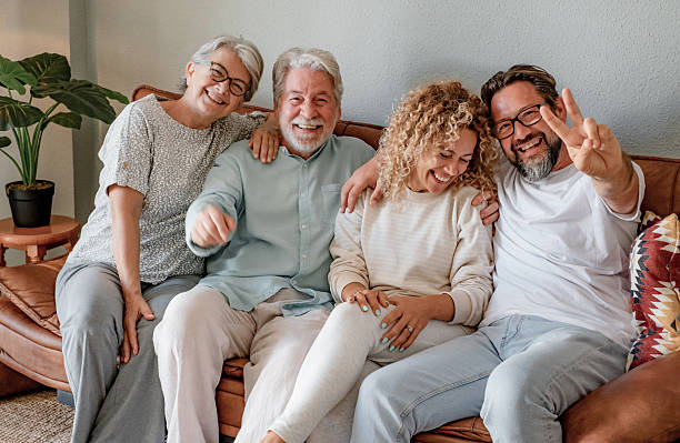 istock Happy multi generation family group relaxing on sofa at home having fun and laughing. Handsome people, parents and adult sons, two generations looking at camera 2247120972