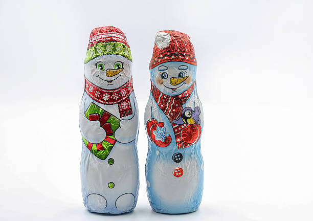 istock Chocolate snowmans wrapped in festive foil packaging closeup on white. 2247121185