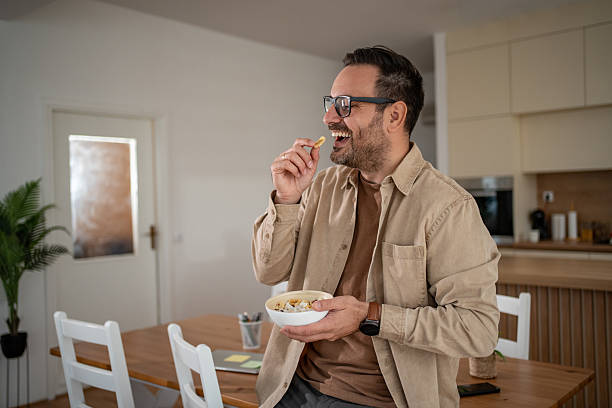istock Happy man eating breakfast cereal at home 2247124058