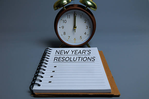 istock Vintage alarm clock at 12:00 AM with a notebook reading “NEW YEAR’S RESOLUTION, 2247124448