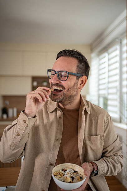 istock Happy man enjoying healthy snack mix at home 2247125043