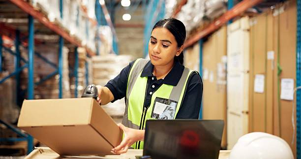 istock Warehouse, shipping and woman with barcode on box for supply chain, freight orders or inventory. Distribution, storage depot and person with scanner on laptop for inspection, logistics and delivery 2247125576