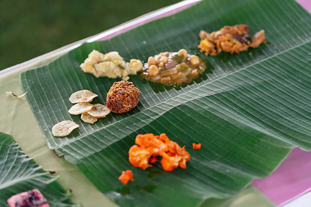 Food placement on banana leaf featuring lentils, snacks, and curry items. South Indian dining tradition, cultural hospitality, and the practice of serving meals on natural leaves.