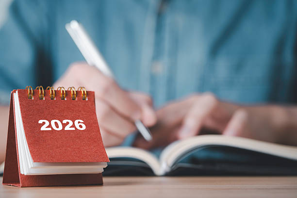 istock Showing a 2026 desk calendar with a person writing in a notebook representing planning organization future goals time management and preparation for the upcoming year in business and personal life 2247131738
