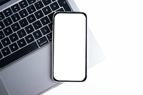 istock Smartphone with blank white screen on laptop over white background. Space for text 2247132399