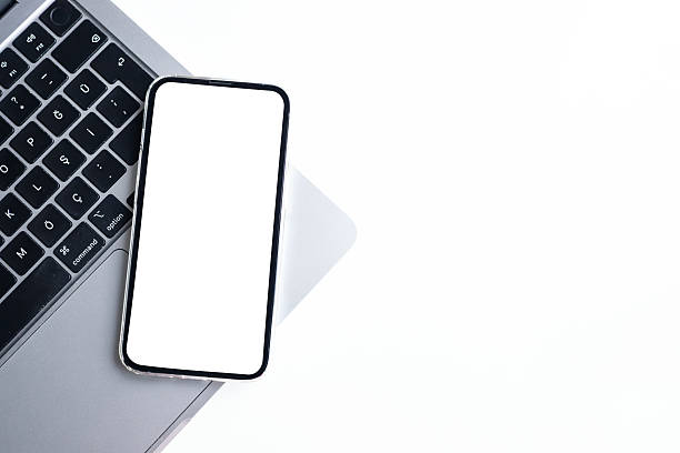istock Smartphone with blank white screen on laptop over white background. Space for text 2247132416