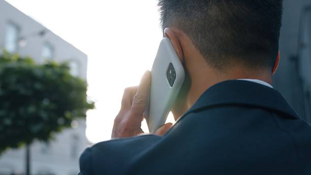 istock Back view business man talking mobile phone calling answer call discuss work businessman talk smartphone speak Asian Korean male entrepreneur busy with telephone negotiation unknown agent in city 2247132662