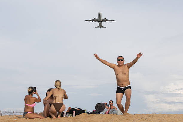 17 November 2025, Mai Khao Beach - Phuket Island.This photo shows people at Mai Khao Beach in Phuket. The beach is known for its long stretch of sand and open shoreline. It is a popular destination for tourists who come to watch planes approach the nearby airport, enjoy the wide beachfront and spend time in a natural coastal setting. The area is less crowded than many other beaches in Phuket, which gives it a more relaxed atmosphere.