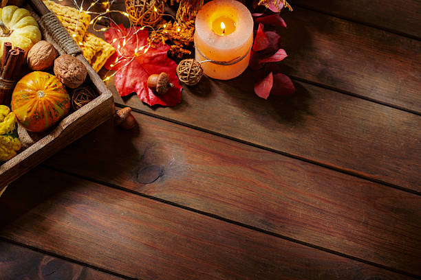 istock Autumnal, October or November frame on wood background with copy space. Burning candle, pumpkins and fallen leaves. Cozy and warm decorated table 2247133652