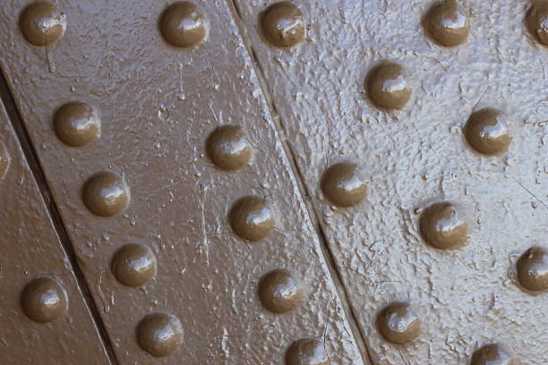 Close up of button head metal rivets, painted brown