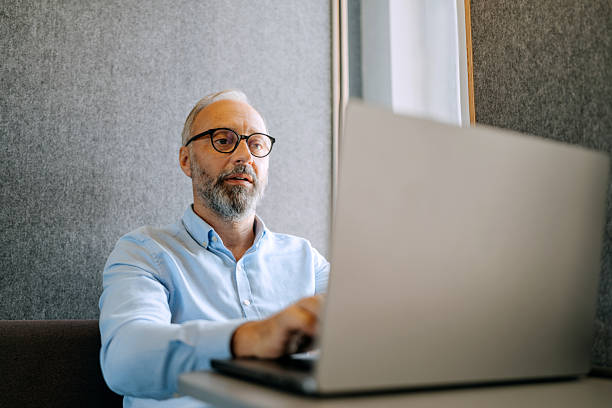 istock Businessman using laptop for video call in office cubicle 2247136814