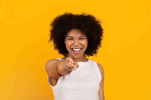 istock Smiling African American woman confidently pointing at camera on yellow studio background 2247137253