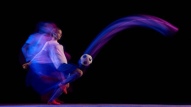 istock Female football player striking ball with speed and precision 2247140431