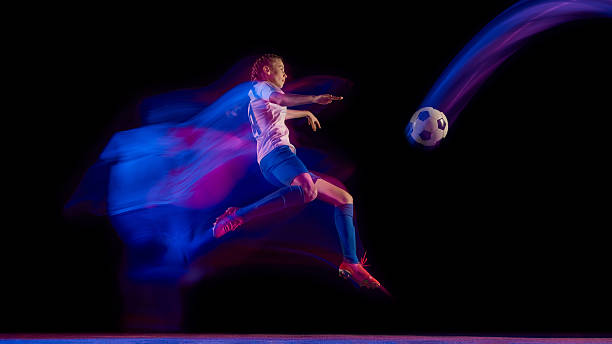 istock Soccer player kicking ball in air with glowing light motion 2247140435