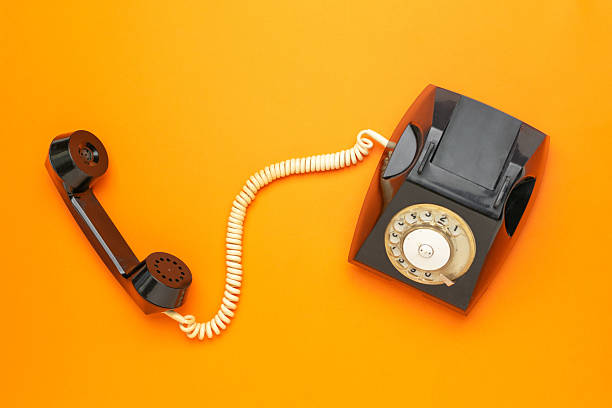 istock Retro Black Rotary Dial Telephone on Vibrant Orange Background 2247142874