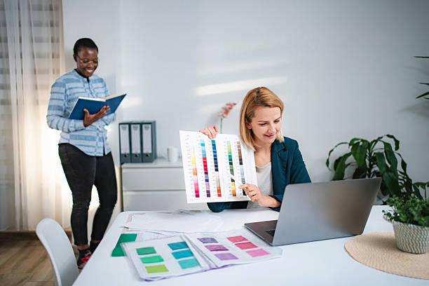istock Coworkers discussing color palette during video call in office 2247143189