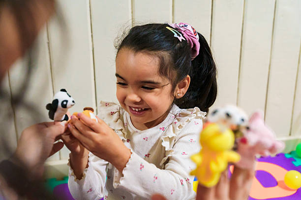 istock Latin american speech therapist playing with child using finger puppets 2247143976
