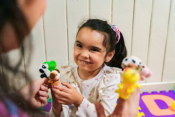 istock Latin american girl learning with speech therapist finger puppets 2247143978