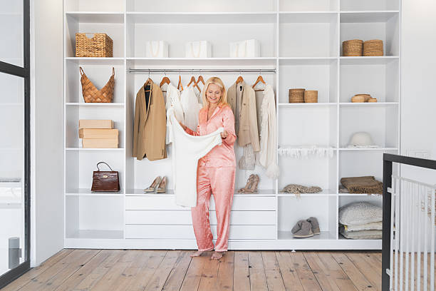 Mature woman picking her clothes in the closet at home