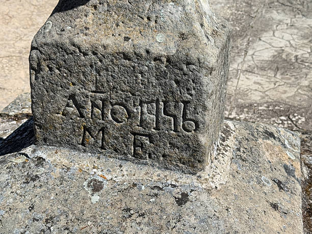 istock Ancient Stone Cross Base with Inscription in Corvio Palencia 2247153974