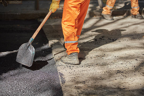 istock Construction worker working on a new asphalt layer on a public street. 2247154854