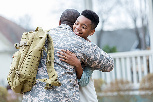 istock Joyful son embraces soldier dad returning home from service with a big smile. 2247154939