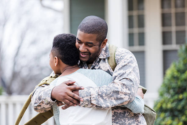 istock A soldier lovingly embraces a child, returning home after a deployment, creating a heartfelt reunion scene. 2247155038