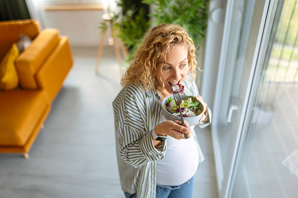 Young Mom-to-Be Looking Outside While Having a Salad