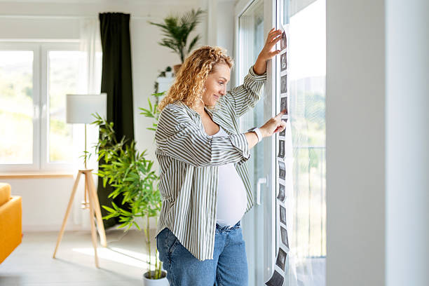 istock Future mom touching belly and looking at ultrasound photos 2247156939