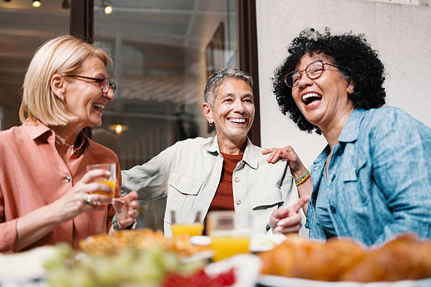 istock Three Middle-Aged Women Laughing While Browsing a Dating App at Brunch 2247157878