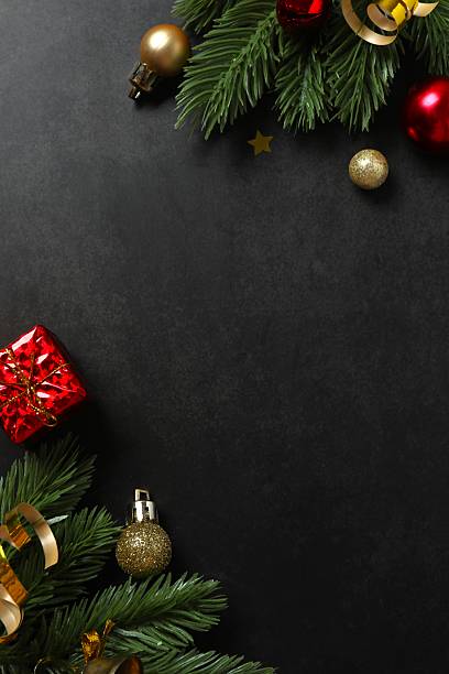 istock Beautiful pine arrangement with various ornaments on black background. A rich Merry Christmas backdrop. Space for text 2247158201