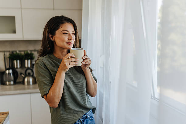 istock Woman enjoying morning coffee looking out window 2247158537