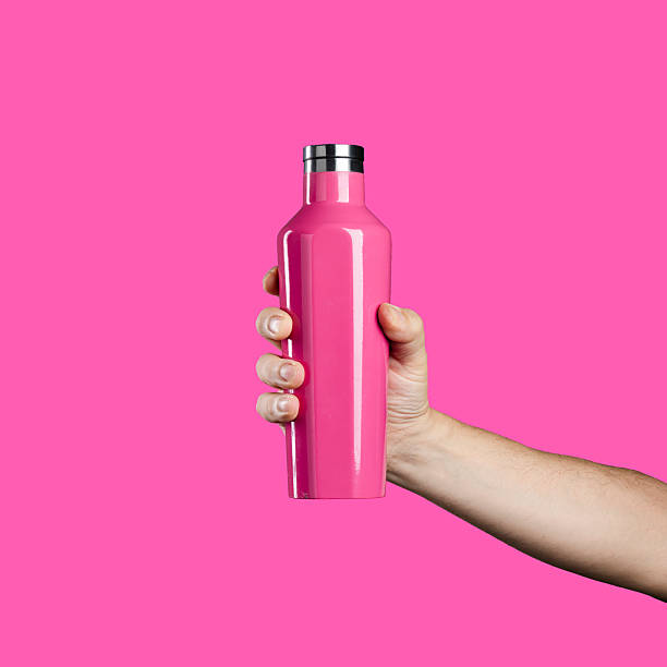 istock Hand holding a pink reusable water bottle on a pink background. 2247158671