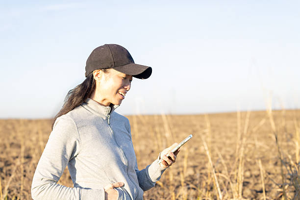 istock Female farmer using smartphone in dry field 2247160414
