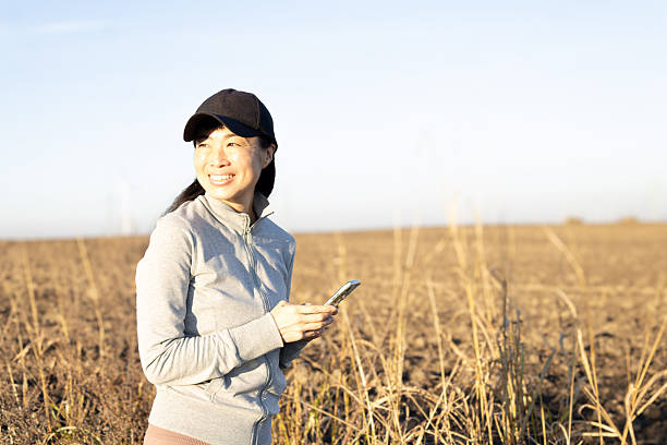 istock Woman smiling using smartphone in rural field 2247160416