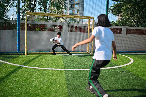 Soccer player practicing dribbling with friends in a team. Group of school teenagers kicking soccer balls during a training session. Boys in football club in cleats improving ball possession skills
