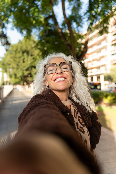 istock Mature adult woman smiling while taking selfie 2247163609