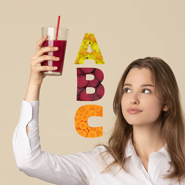 Beautiful woman drinking red juice with straw