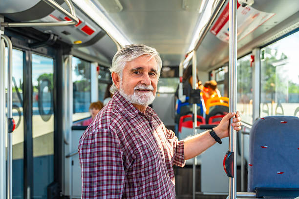istock Senior man smiling, riding public transit bus 2247168213