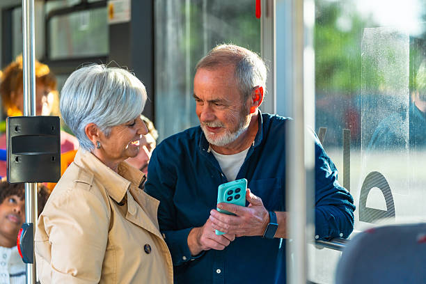istock Senior couple sharing smartphone while riding public bus 2247168258