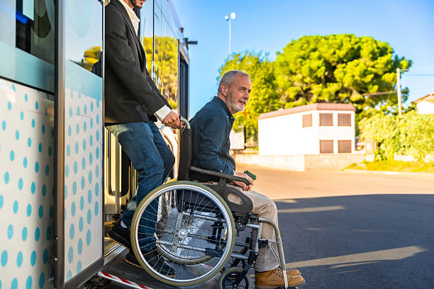 istock Bus driver assisting man in wheelchair boarding public transport 2247168549