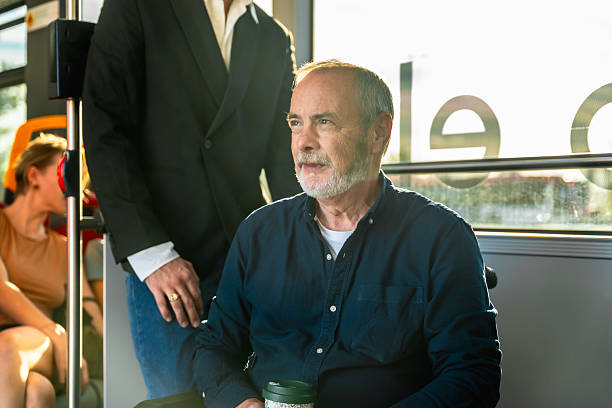 istock Senior man commuting on bus with reusable coffee cup 2247168595