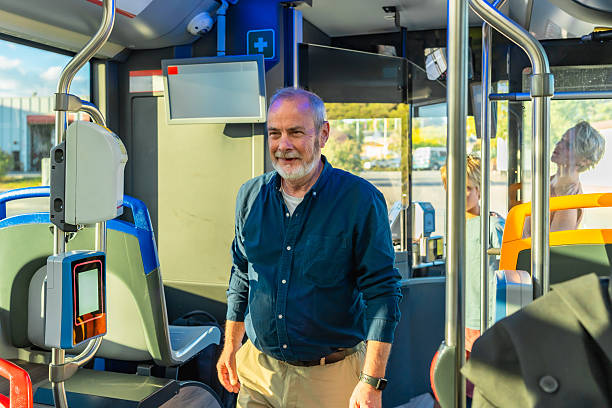istock Senior man smiling while riding public transportation bus 2247168686