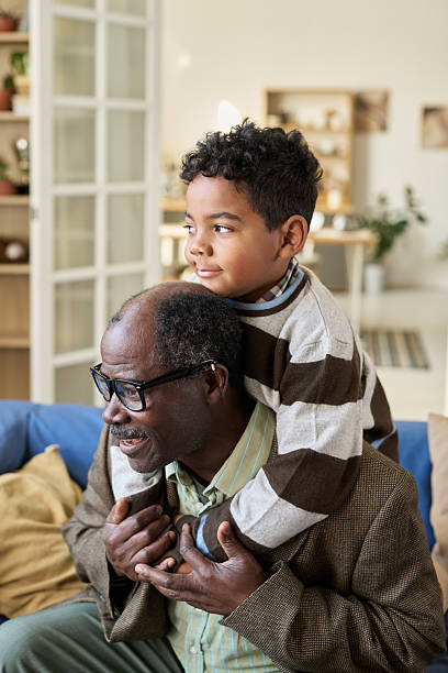 istock Senior Black Man Carrying Black Boy on Shoulders Indoors Smiling 2247172483