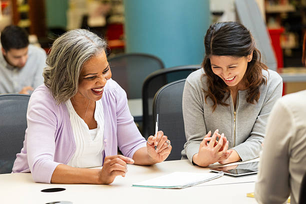 istock Diverse group of people collaborating and laughing during a meeting or class session 2247174103