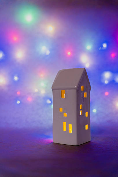 istock White ceramic house creating warm light with colorful Christmas string lights glowing in soft bokeh 2247174385